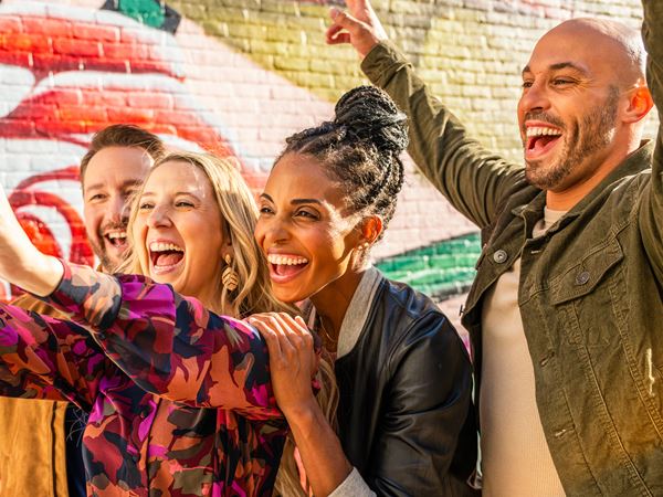 Friends Taking Selfie in front of Painted Wall